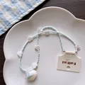 Close-up detail of a summer island shell beaded necklace with heart-shaped accents - No.6 Cream Knot Shell