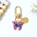 Elegante gouden sleutelhanger met kleurrijke vlinder en een LOVE-bedelplaatje - Paars En Roze Gradiëntstijl (B)