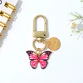 Elegante roze vlinder sleutelhanger met een gouden gegraveerde Love bedel detail. - Roze Paars Zwart Stijl (D)