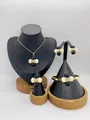 Detailed view of women's stainless steel jewelry set on black display stands - Black and White Bead Cross Style (LX030010 Black and White)