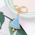 Detalle de un llavero de árbol de Navidad en esmalte azul claro con cristales brillantes. - Azul lago
