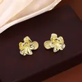 Gros plan sur des boucles d'oreilles fleurs dorées de style vintage en métal irrégulier - Fleur Or (E3743-2)