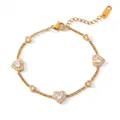 Primo piano di un elegante bracciale in acciaio titanio dorato con cuori lucenti - Bracciale Con Cuore Di Diamanti