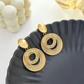 Détail de boucles d'oreilles créoles spirales dorées multicouches sur un plateau noir - Créole Spirale Or (E4892)