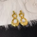 Vue macro très détaillée de boucles d'oreilles rétro en or martelé pour femmes. - Goutte Martelé Or (E2414)