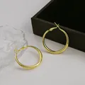 Détail de boucles d'oreilles créoles dorées élégantes au fini métal brillant - Petite Créole Or (E3350-5)