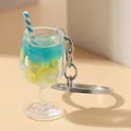 Gedetailleerde macro-weergave van een miniatuur drank sleutelhanger met citroen en rietje. - Blauw-6699