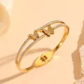 Macro view showing the frosted butterfly details and secure clasp of the golden bangle - Double Layer Butterfly (H716)