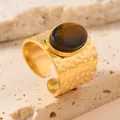 Detailed view of gold stainless steel ring with hammered texture and oval brown stone - One Size / Brown