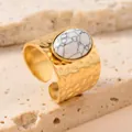 Détail d'une bague en acier doré avec pierre blanche ovale et texture martelée. - Taille unique / Blanc Porcelaine