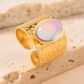 Detalle de un anillo de acero inoxidable martillado dorado con piedra de ópalo - Talla única / Azul
