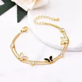Close-up detail of 18K gold-plated titanium steel double chain bracelet with butterflies - 18K Gold / Black Butterfly