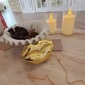 Gold lip-shaped acrylic clutch bag with chain on wooden table with candles - Gold