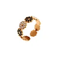 Vue détaillée d'une bague ouverte en acier doré avec des marguerites en émail noir et blanc. - Style Marguerite Noir et Blanc (R2595-01)