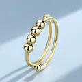 Macro view of a gold-plated fidget ring featuring rotating beads for anxiety relief - Adjustable Open / Geometric Beaded - Gold Color