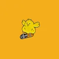 Detail einer süßen gelben Emaille-Anstecknadel mit Küken auf einem Skateboard. - Gelbe Skateboard-Ente