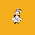 Detail of a cute white duck enamel pin wearing bunny ears and a crossbody bag - Rabbit Ears Duck