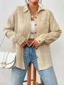 Detail view of a beige long-sleeved crinkle shirt with drop shoulder and brown buttons. - Khaki