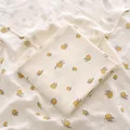 Gros plan d'un lange en mousseline de coton pour bébé avec un motif de citron jaune - 100x100cm / Petite Olive