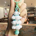 Close-up of a cute white Cinnamoroll stacked figure keychain for backpack decor - 00000 Sanrio Jenga - Cinnamon Dog Green