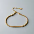 Detail view of a gold-plated stainless steel flat snake chain bracelet with clasp. - Flat Snake Chain (ne274) / Gold