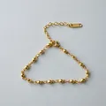 Detailed view of a golden stainless steel bead chain bracelet with lobster clasp - Round Bead Fine Chain (ne275) / Gold