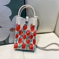 Detailed close-up of a small knitted phone bag featuring vibrant orange tulip embroidery - Silicone Phone Case #5