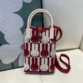 Detail of a red and white knitted rabbit pattern mini tote bag with cream handles and strap. - Silicone Phone Case #20