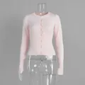 Dettaglio ravvicinato di un cardigan in maglia rosa chiaro slim fit con bottoni frontali - S / Rosa