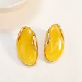 Elegant irregular yellow resin stud earrings with minimalist gold metal trim design - Gold