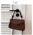 Detailed view of the brown textured retro crossbody bag hanging on a white door - Brown