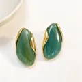 Elegant irregular green resin stud earrings with artistic gold metal wrap details - Malachite green