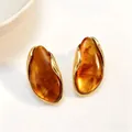 Elegant irregular amber resin earrings with a gold finish and minimalist aesthetic - Amber
