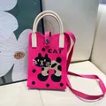 Vibrant pink knitted mini tote phone bag featuring black cat pattern and cream handles - Silicone Phone Case #7