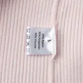 Primo piano dell'etichetta di cura su un cardigan in maglia rosa, taglia S, dettaglio - S / Rosa