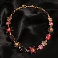 Vista detallada de un collar de flores de cristal vintage sobre terciopelo negro mate - Rosa-Púrpura