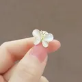 Dettaglio macro di una elegante spilla a farfalla con ali di opale nella mano - Delicata Spilla A Forma Di Farfalla