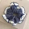 Vue détaillée d'un grand chouchou à carreaux bleu marine avec bords à volants blancs - Style Rond Petit Carreaux Bleu Foncé