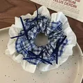 Detail view of a large blue and white plaid scrunchie with lace ruffles and bows. - Dark Blue Plaid Round Style (26596B)