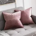 Twee elegante oudroze fluwelen kussenslopen met decoratieve biezen op een grijze bank - Oudroze / 30x50cm