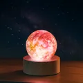 Detailed close-up view of a glowing colorful galaxy crystal ball on a round wooden base. - Pink Sphere With Base