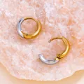 Gros plan de créoles bicolores en acier titane or et argent sur une pierre rose. - Rond / 16mm / Bicolore Or et Argent