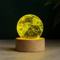 Detailed view of a glowing planet crystal ball lamp on a natural wooden base stand - Yellow Sphere With Base