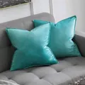 Pair of teal velvet pillow covers with elegant flanged edges shown on a modern grey sofa - Cyan Blue