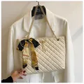 Detail of quilted creamy white shoulder bag with silk scarf bow and gold chain strap - Off White