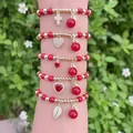Stack of five red and gold beaded cherry bracelets with heart and cross zircon charms - Red Bead Cherry 5-Piece Set (B1)