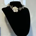 Detailed view of a vintage-style flower choker necklace on a black display bust. - Beaded Flower Necklace