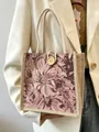 Detailed shot of a floral tapestry handbag with rope handles and wooden button - Pink Button Style