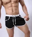 Macro view of black men's athletic shorts featuring white trim and drawstring waist - M / Black