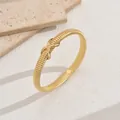 Elegant gold snake bone textured bracelet with minimalist X-cross decorative knot. - Cross Knot Snake Bone Bangle / 3500 Gold